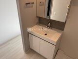 ヴィスタコート幡ヶ谷 白基調の洗面台と鏡、収納付きの落ち着いた洗面室