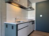 ヴィスタコート幡ヶ谷 モダンなアイランドキッチンと白いバックパネルの落ち着いた空間