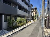 ラヴィエール住吉駅前 前面道路から見たモダンな建物外観と緑が映える入り口周り