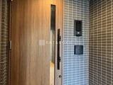 ラヴィエール住吉駅前 木目調ドアと落ち着いたタイル貼りのエントランスホール