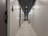 ラヴィエール住吉駅前 落ち着いた照明の共用廊下に並ぶ複数の住戸入口