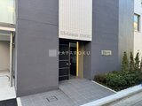 エスグランデ大森 濃いグレーの外壁に黒いエントランスドアが映える建物の入り口