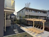 エスグランデ大森 木製パーゴラとウッドデッキのある開放的な庭園スペース