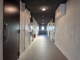 エスグランデ大森 両側に居室ドアが並ぶ廊下と奥の出入口の様子