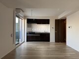エスグランデ大森 開放的なリビングダイニングと黒を基調としたキッチンの一体空間