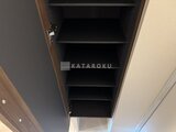 エスグランデ大森 複数の棚を備えた開き戸の黒い収納スペース
