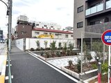 アルコバレーノ南千住 整えられた庭園と周辺建物が見える物件の外観