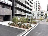 アルコバレーノ南千住 緑豊かなエントランス前の庭園と建物外観