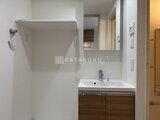 アルコバレーノ南千住 木目調の洗面台と鏡が備わった、清潔感のある洗面脱衣室