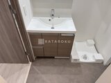 アルコバレーノ南千住 木目調の洗面化粧台と温水洗浄便座付きのトイレが備わった洗面所