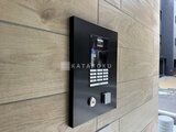 ルミーク大森 木目調の壁に設置されたモダンなエントランスの機器パネル