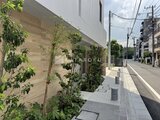 ルミーク大森 緑を配置した開放的な共用通路と建物外観