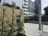 ルミーク大森 緑化された塀と駐車場が広がる開放的な共用部の様子
