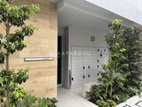 ルミーク大森 木調パネルと緑に囲まれた明るいエントランスと宅配ボックス