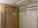 ルミーク大森 木目調パネルと白いシャワーブースのモダンな浴室
