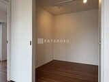ルミーク大森 白い建具の開口部から見た落ち着いた色合いの洋室
