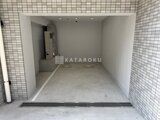アルコバレーノ亀戸2 白いタイル貼りの開放的なエントランスから見た駐車スペース