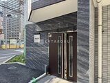 アルコバレーノ亀戸2 暗色の石張りと濃い色の門扉が落ち着いた印象のエントランス
