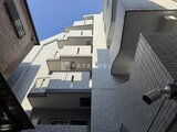 アルコバレーノ亀戸2 白いタイル張りの外壁と段差のあるバルコニーが印象的な建物外観