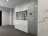 アルコバレーノ亀戸2 大理石調の壁と宅配ボックスが備わるモダンなエントランスホール