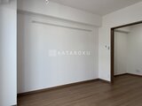 アルコバレーノ亀戸2 白い壁と落ち着いた色合いの木製フローリングの居室