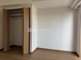 アルコバレーノ亀戸2 木目調のドアが開いたクローゼットと広々とした洋室の様子