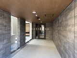 タスキスマート新大塚3 木調天井と石貼り壁が落ち着いた印象の共用廊下