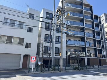 タスキスマート新大塚3 街路から見たモダンな外観の建物と隣接する周辺街並み
