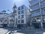 タスキスマート新大塚3 日中の陽光が映える、モダンなデザインの建物外観