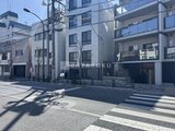 タスキスマート新大塚3 横断歩道から見たモダンな建物と周辺街並みの様子