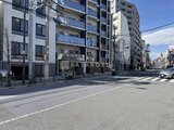 タスキスマート新大塚3 前面道路から見たモダンな複合建物の外観