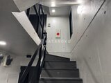 タスキスマート新大塚3 モダンな階段室とモノトーン基調の共用廊下の様子