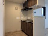タスキスマート新大塚3 木目調キャビネットと白を基調とした料理スペース