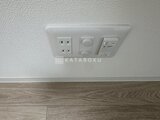 タスキスマート新大塚3 白い壁面に設置されたコンセントと照明スイッチ
