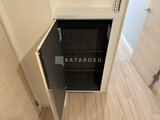 タスキスマート新大塚3 明るい床材に映える黒い棚板の収納スペース
