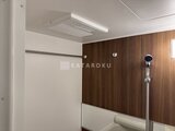 タスキスマート新大塚3 浴室の木目調パネルと白いタイルを組み合わせた落ち着いた空間