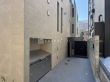 ザ・レジデンス市谷台町 車庫入口とモダンな外壁を備えた建物の駐車スペース