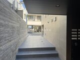 ザ・レジデンス市谷台町 明るい日差しが入る階段踊り場から見たエントランスアプローチ
