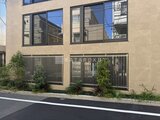ザ・レジデンス市谷台町 前面道路から見た、縦格子フェンスと大きな窓が特徴的な建物外観