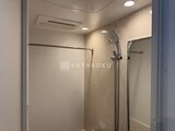 ザ・レジデンス市谷台町 明るい照明と天井換気扇を備えたシャワーブース付きのバスルーム
