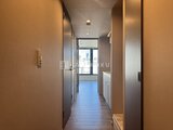 ザ・レジデンス市谷台町 明るい採光が入る廊下と、奥に見えるバルコニーの様子