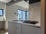 ザ・レジデンス市谷台町 モダンなキッチンから見たリビングダイニングの開放的な様子