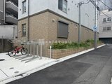 ラヴィエール新板橋 自転車置き場と緑を備えた建物の側面外観