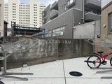 ラヴィエール新板橋 自転車置場と周辺建物が見える開放的な外部スペース