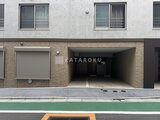 ラヴィエール新板橋 建物前面の駐車場入口と落ち着いた印象のファサード