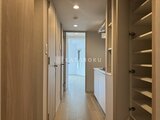 ラヴィエール新板橋 木調の扉と収納が整然と並ぶ廊下から洗面室へつながる空間