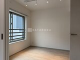 ラヴィエール新板橋 明るい光が入る洋室、木質フローリングと白壁のシンプルな空間