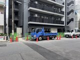 アーバネックス両国レジデンス モダンな外観の建物と共用駐車スペースの様子