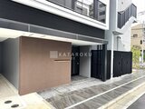 アーバネックス両国レジデンス 建物前のエントランスと黒いスクリーン付きの駐車場スペース