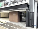 アーバネックス両国レジデンス 建物低層部のモダンなエントランスと駐輪場の様子